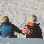dzieci siedzą na śniegu
