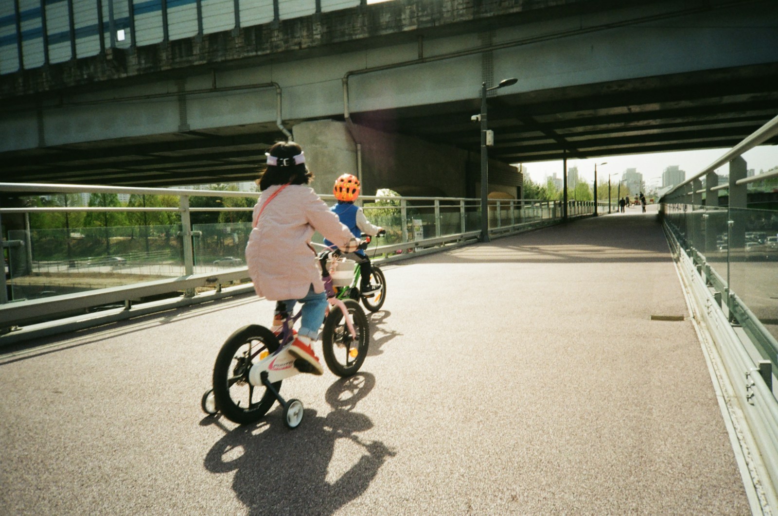 dzieci jadące na rowerkach z tylnymi kołami