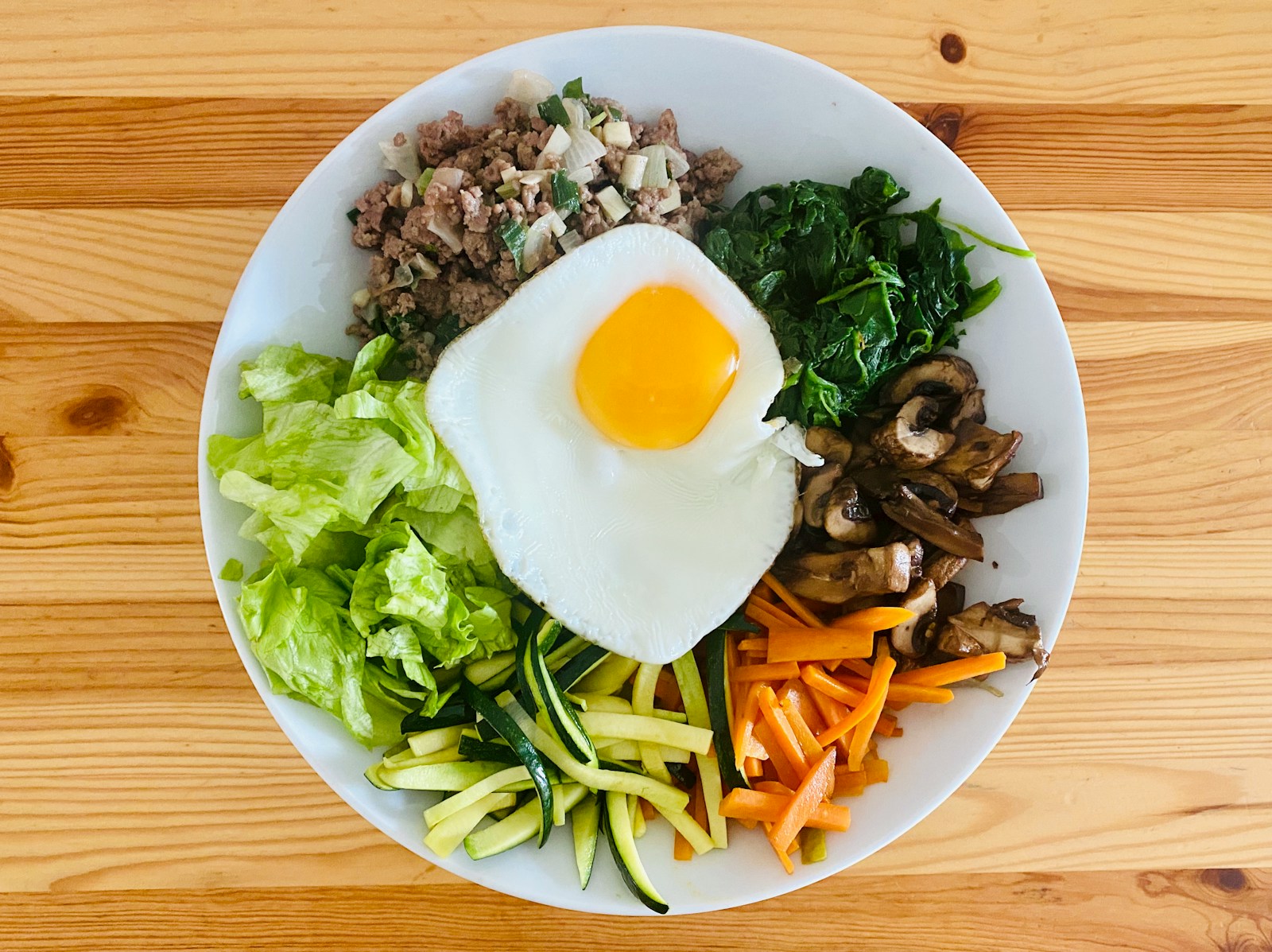 jajko z warzywami i mięsem na talerzu